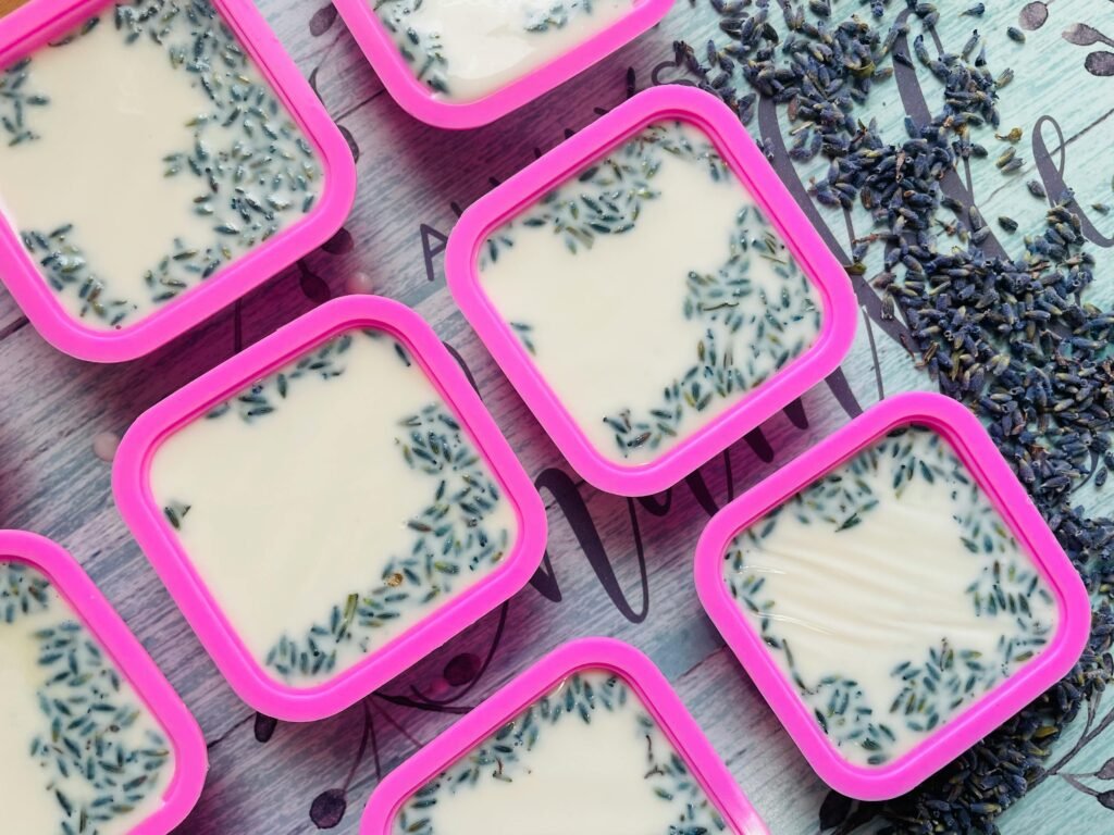 Top view of handmade lavender soap bars in pink molds with dried lavender sprinkles.