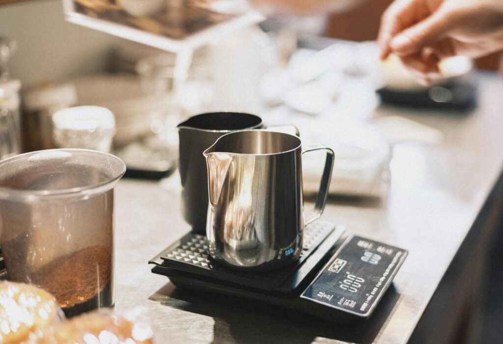 A barista prepares coffee using a shining pitcher and scale at a café in Shinjuku, Tokyo, Japan.