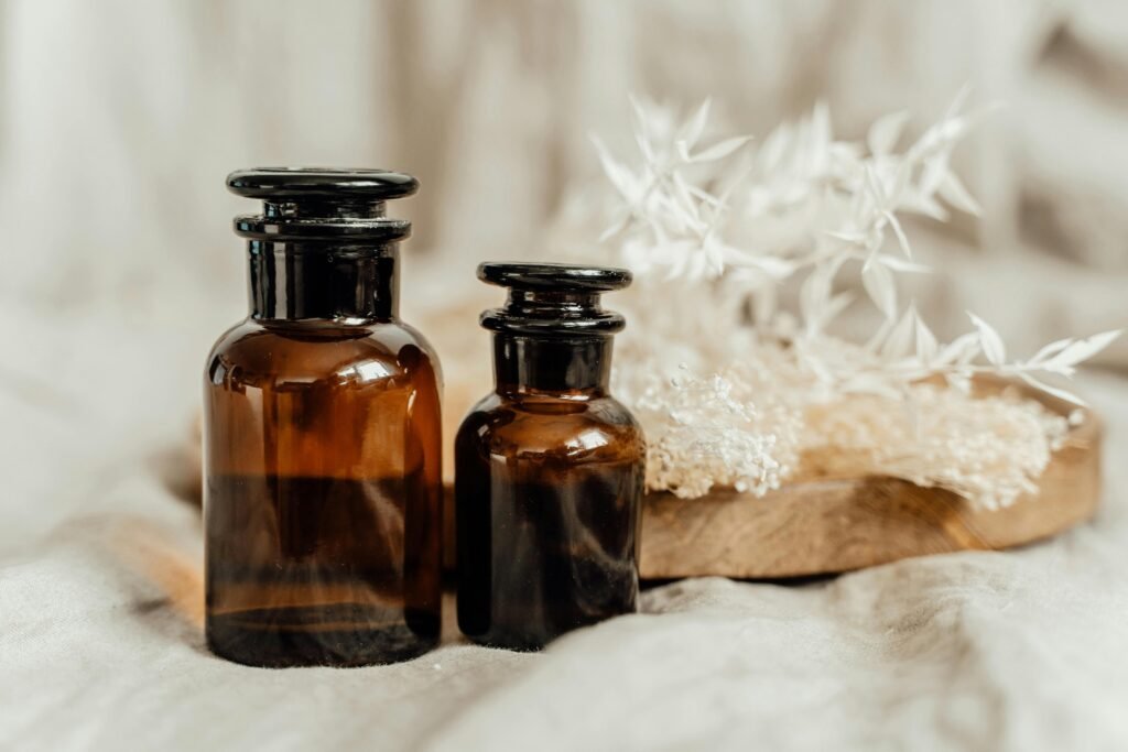 Brown glass aromatherapy bottles with white flowers in a calming still life composition.